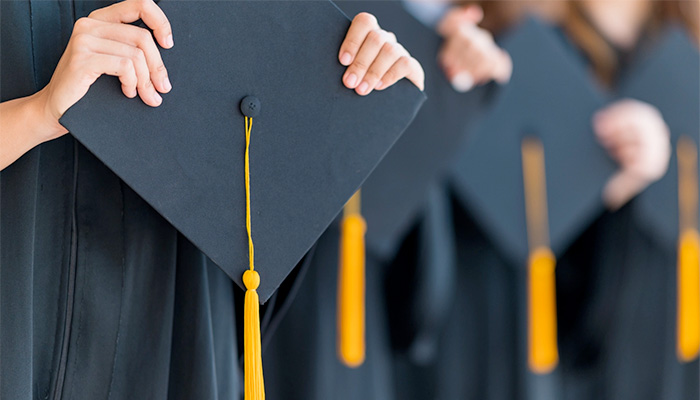 Hands holding a graduation cap