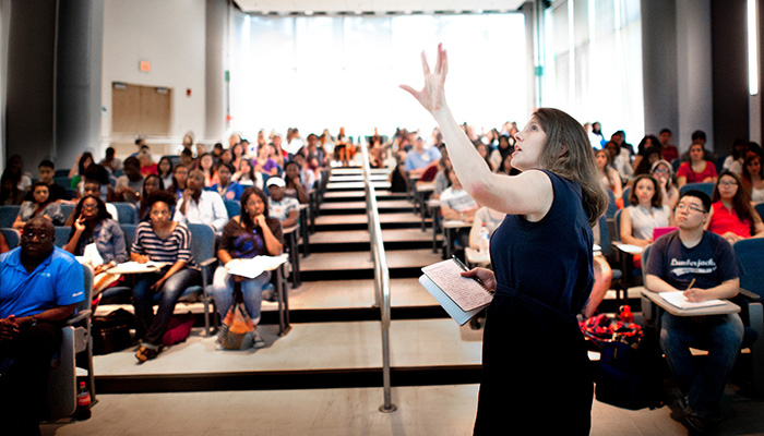 Instructor standing in front of an auditorium of students